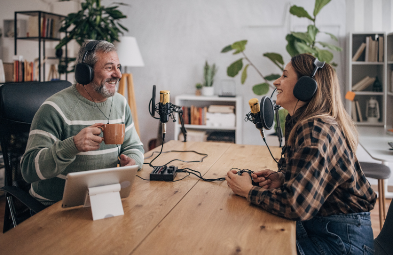 podcast skills for marketing and branding - two people sitting at a wooden table talking and recording a podcast